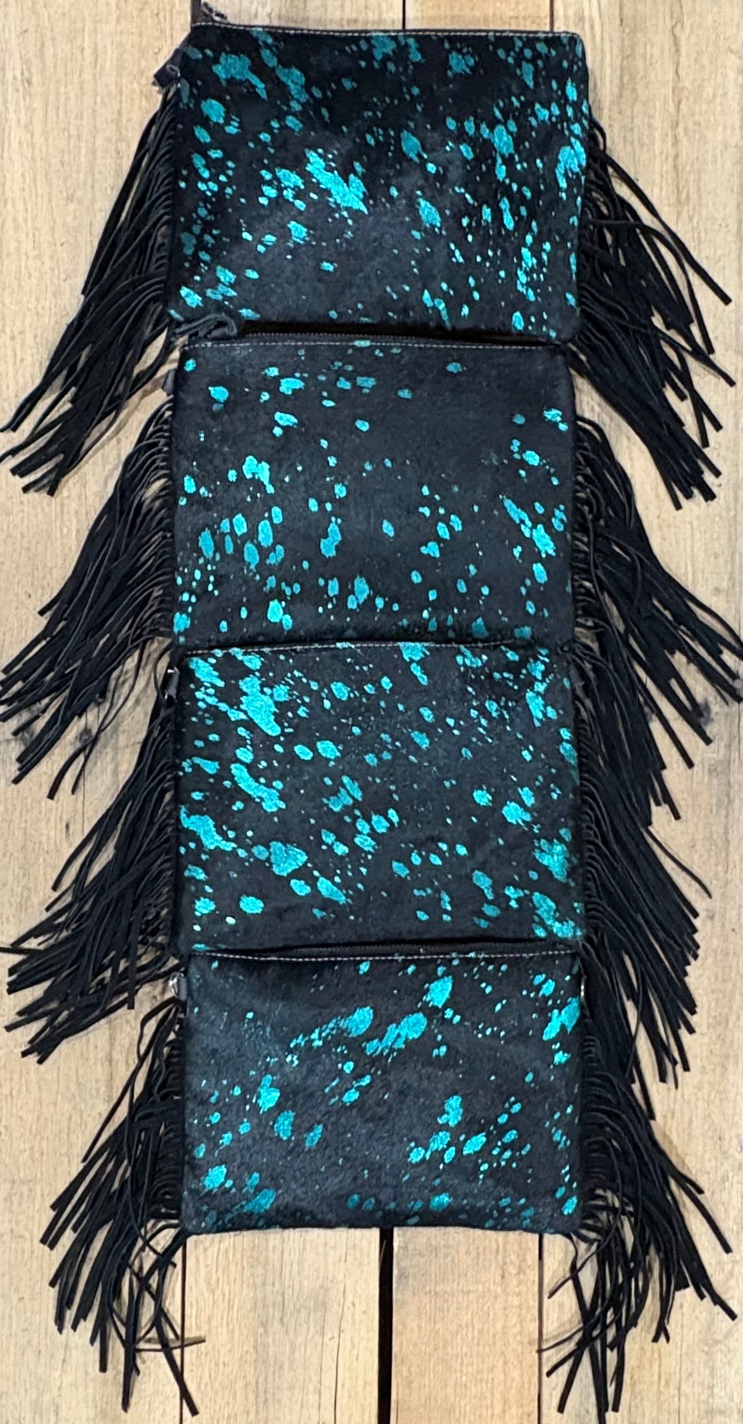 Four purse view of Turquoise and black hairon crossbodys on a wooden background