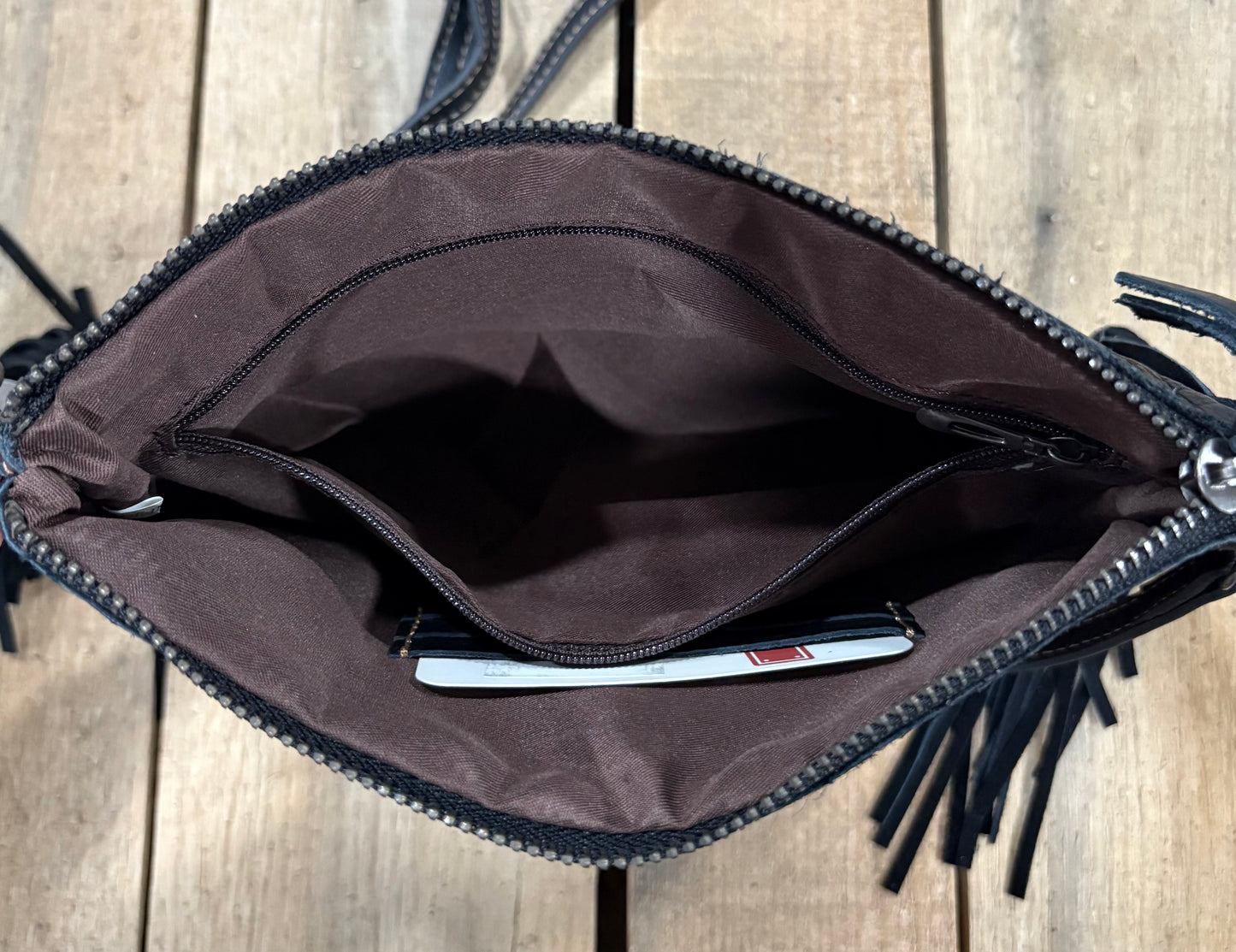 Inside Zipper view of a black leather crossbody purse.