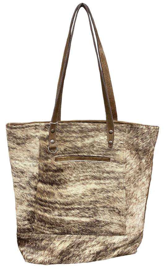 Tote bag with cowhide pattern and brown leather handle on a white background