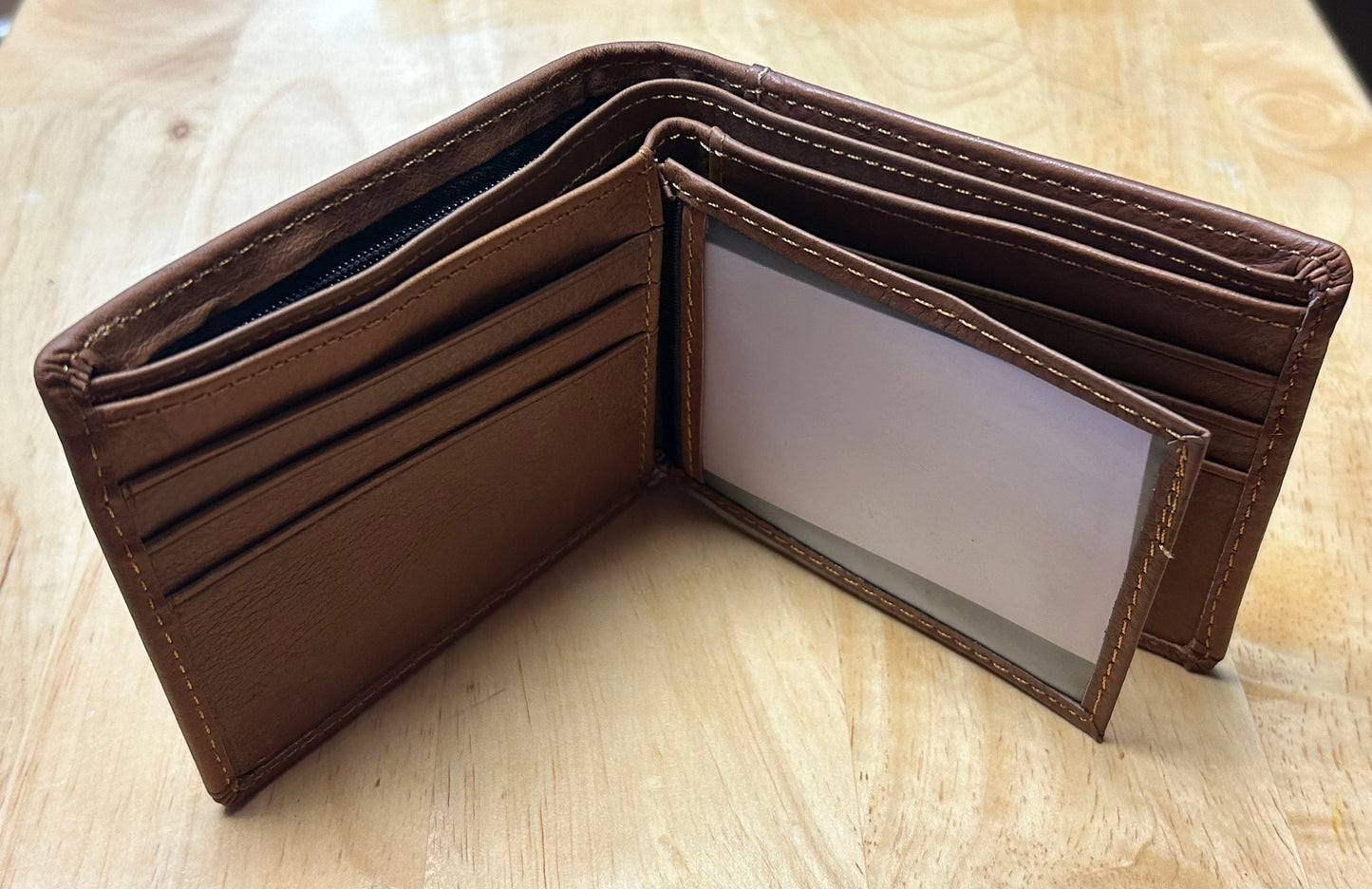 Brown leather wallet open on a wooden surface