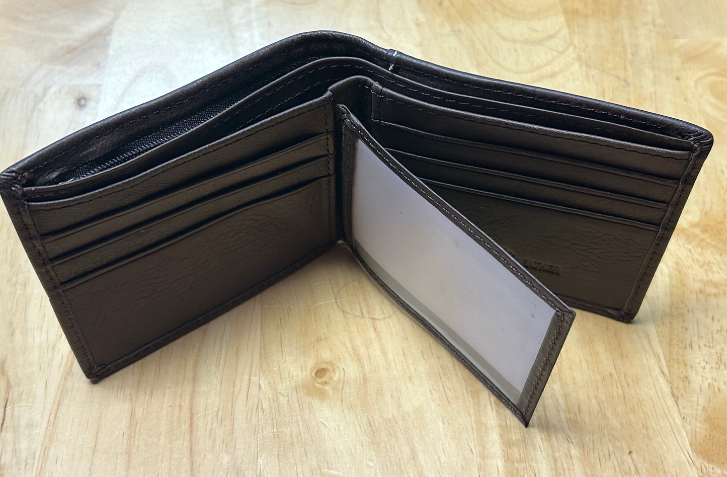 Brown leather wallet open on a wooden surface