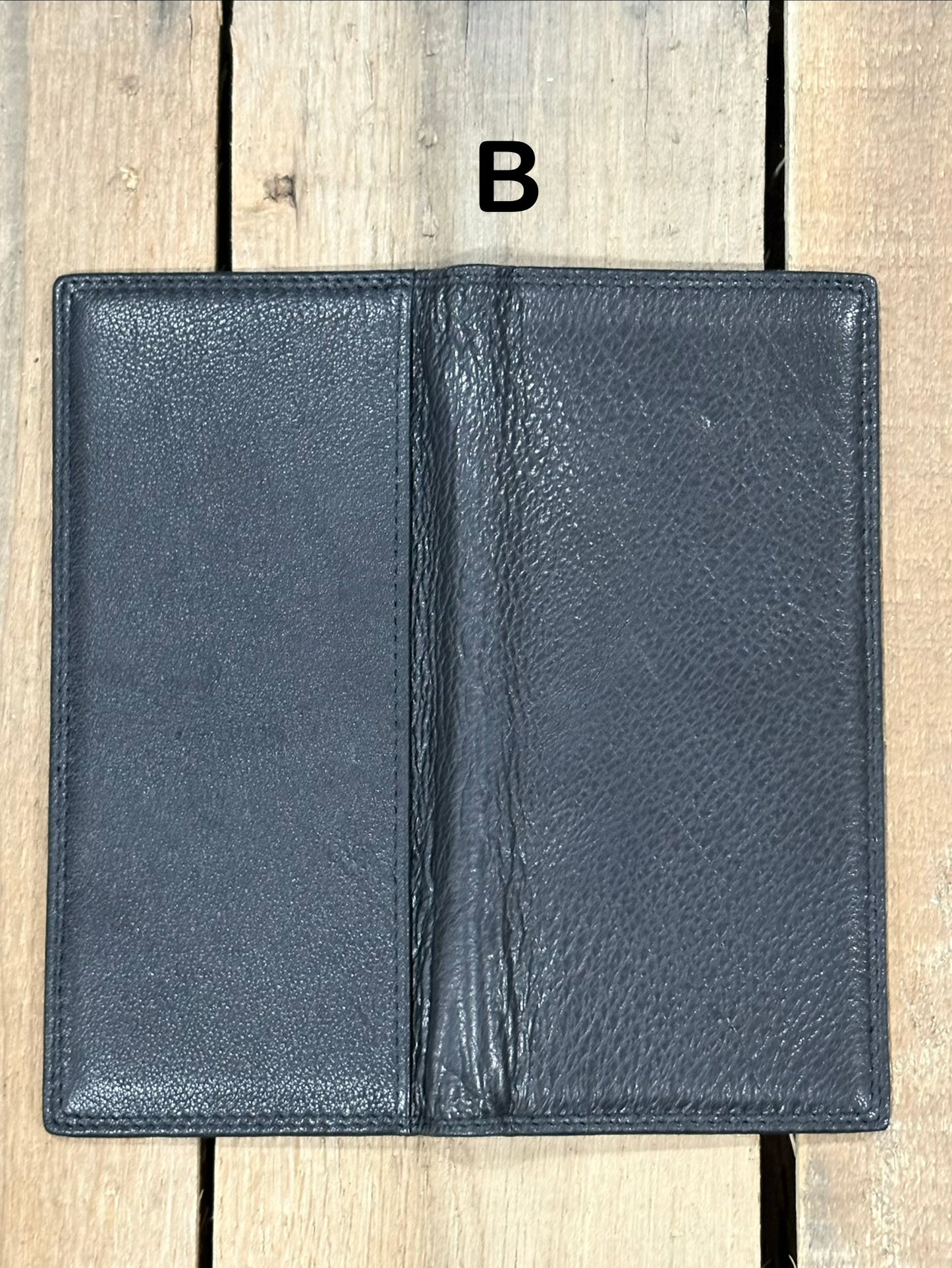 Black leather wallet open on a wooden surface