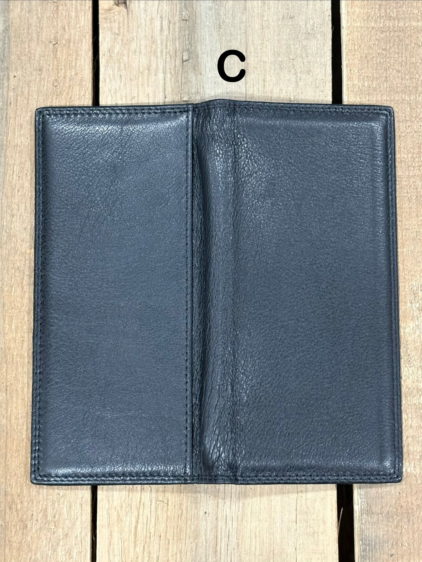 Black leather wallet on a wooden surface