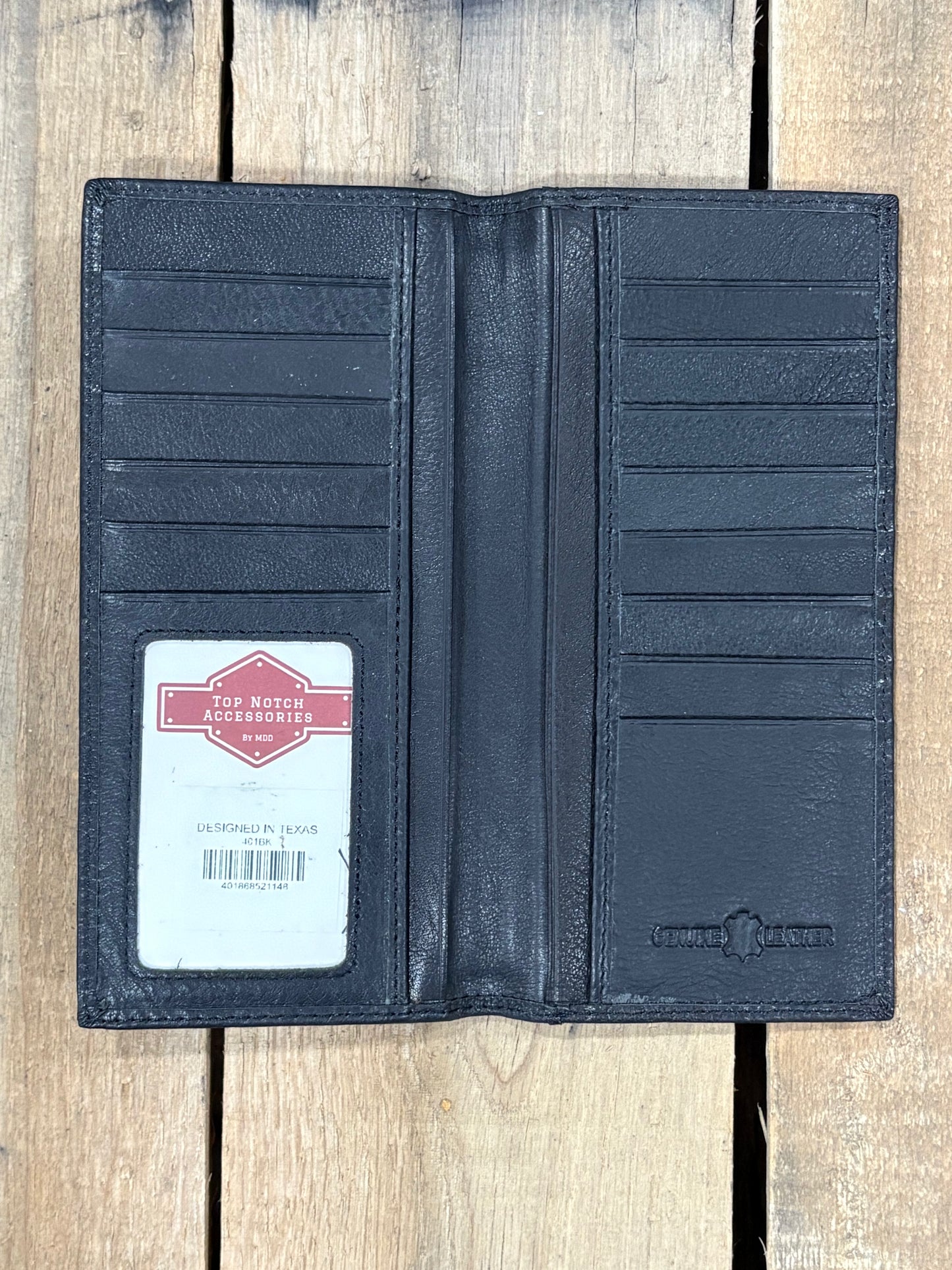 Black leather wallet with a brand label on a wooden surface