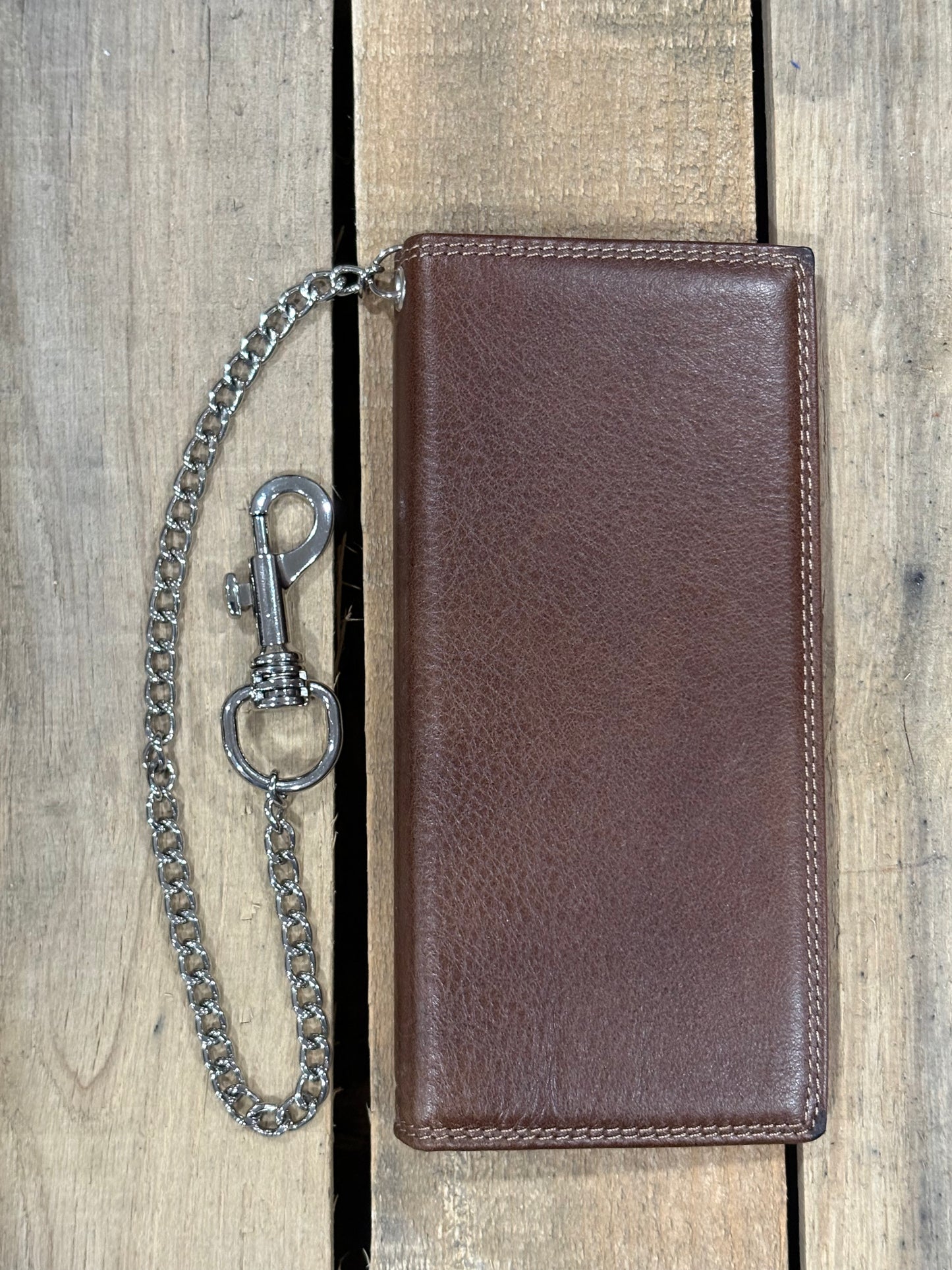 Brown leather wallet with a chain and clasp on a wooden background
