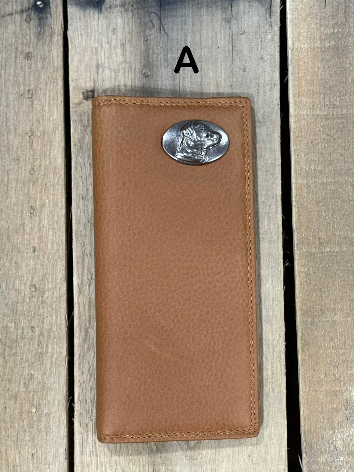 Brown leather wallet with a lab head silver concho on a wooden surface