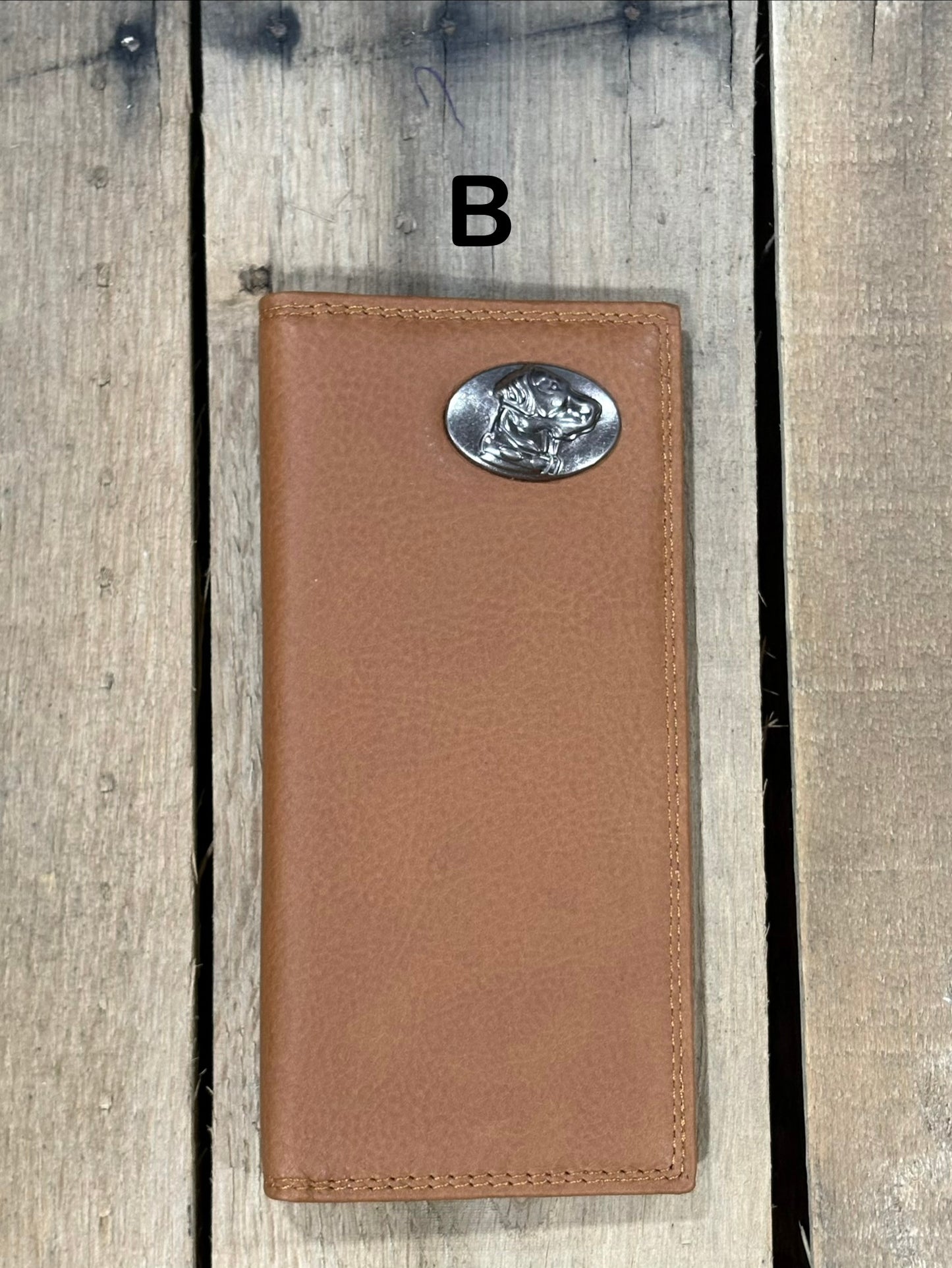 Brown leather wallet with a lab head silver concho on a wooden surface