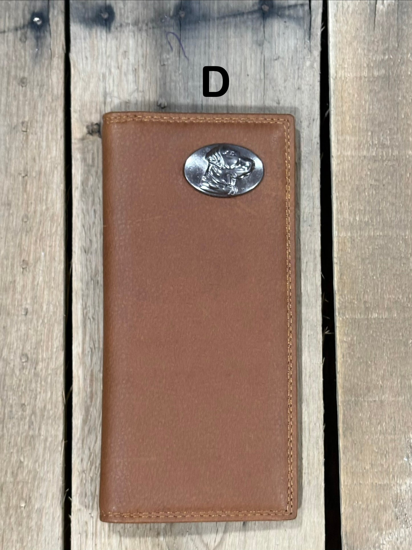 Brown leather wallet with a lab head silver concho on a wooden surface
