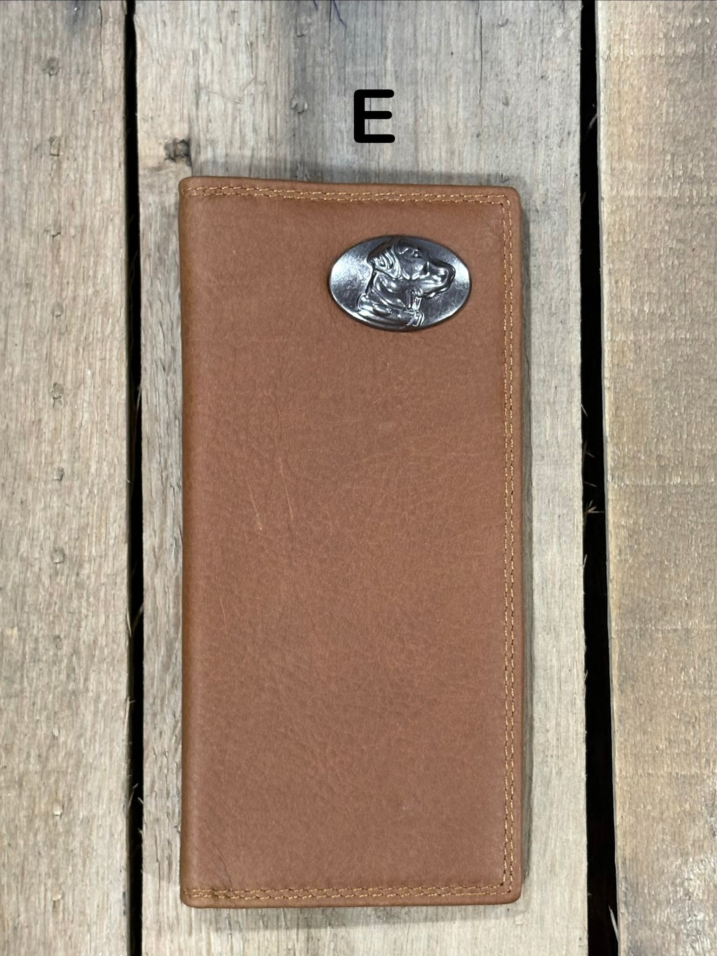 Brown leather wallet with a lab head silver concho on a wooden surface