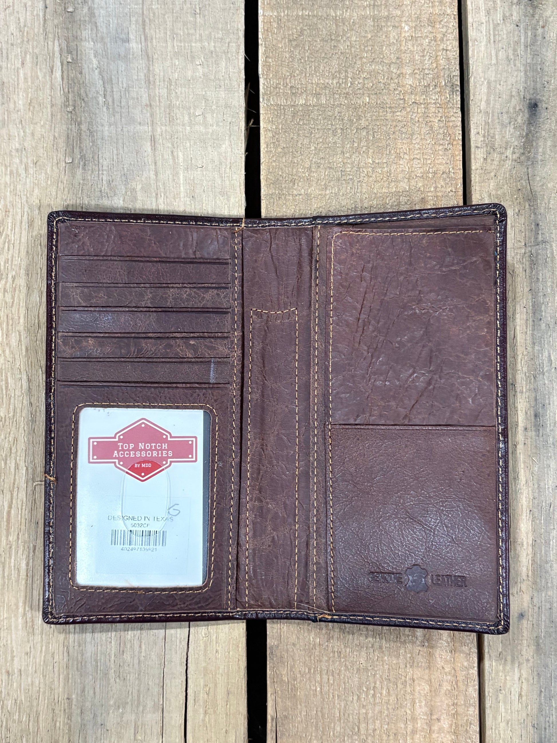 Coffee Brown leather wallet inside view with Top Notch Accessories Card inside ID window slot, 6 card slots, pen slot, and currency pocket on a wooden surface background