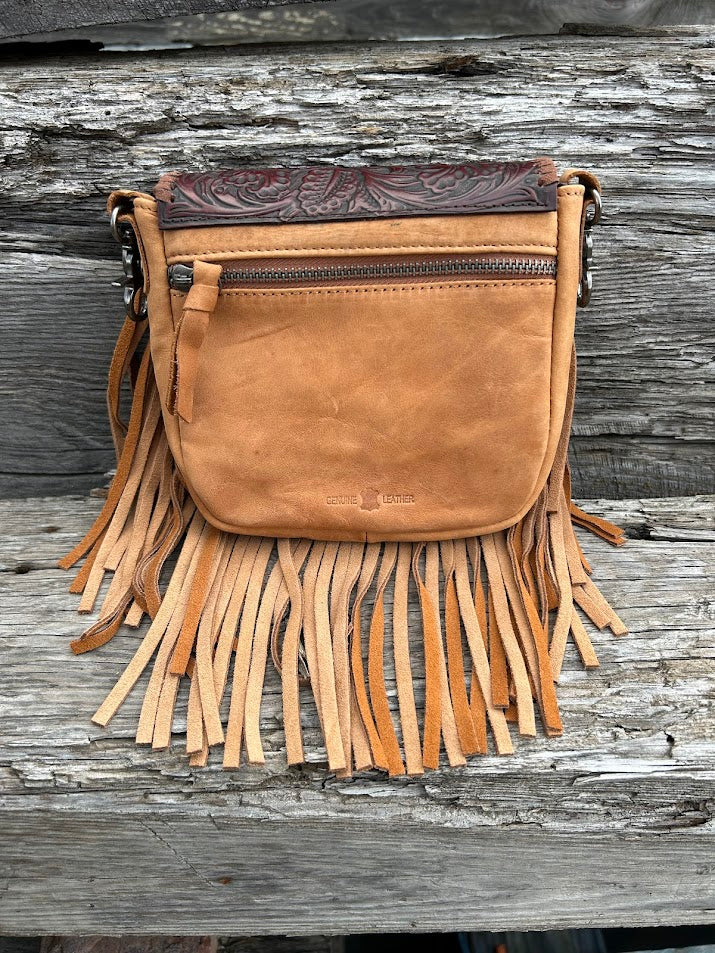This Brown embossed leather crossbody bag features fringe sounds and it has a removable and adjustable should strap. This bag has a front flap and a zippered closed back pocket. It measures 6 inches tall, 6 1/4 inches wide and is 1 /12 inches deep.