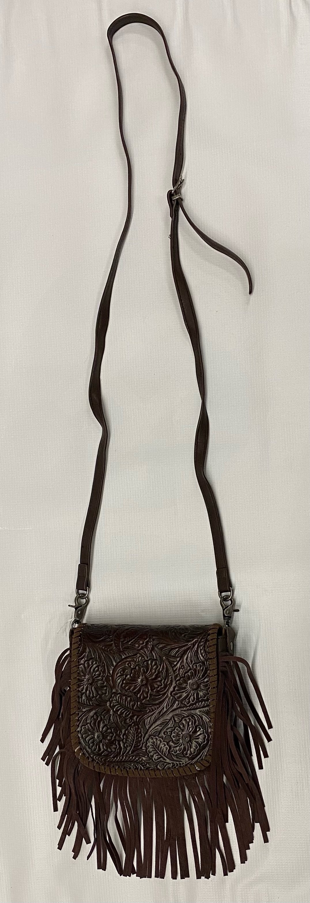 Brown leather crossbody bag with fringe details on a white background