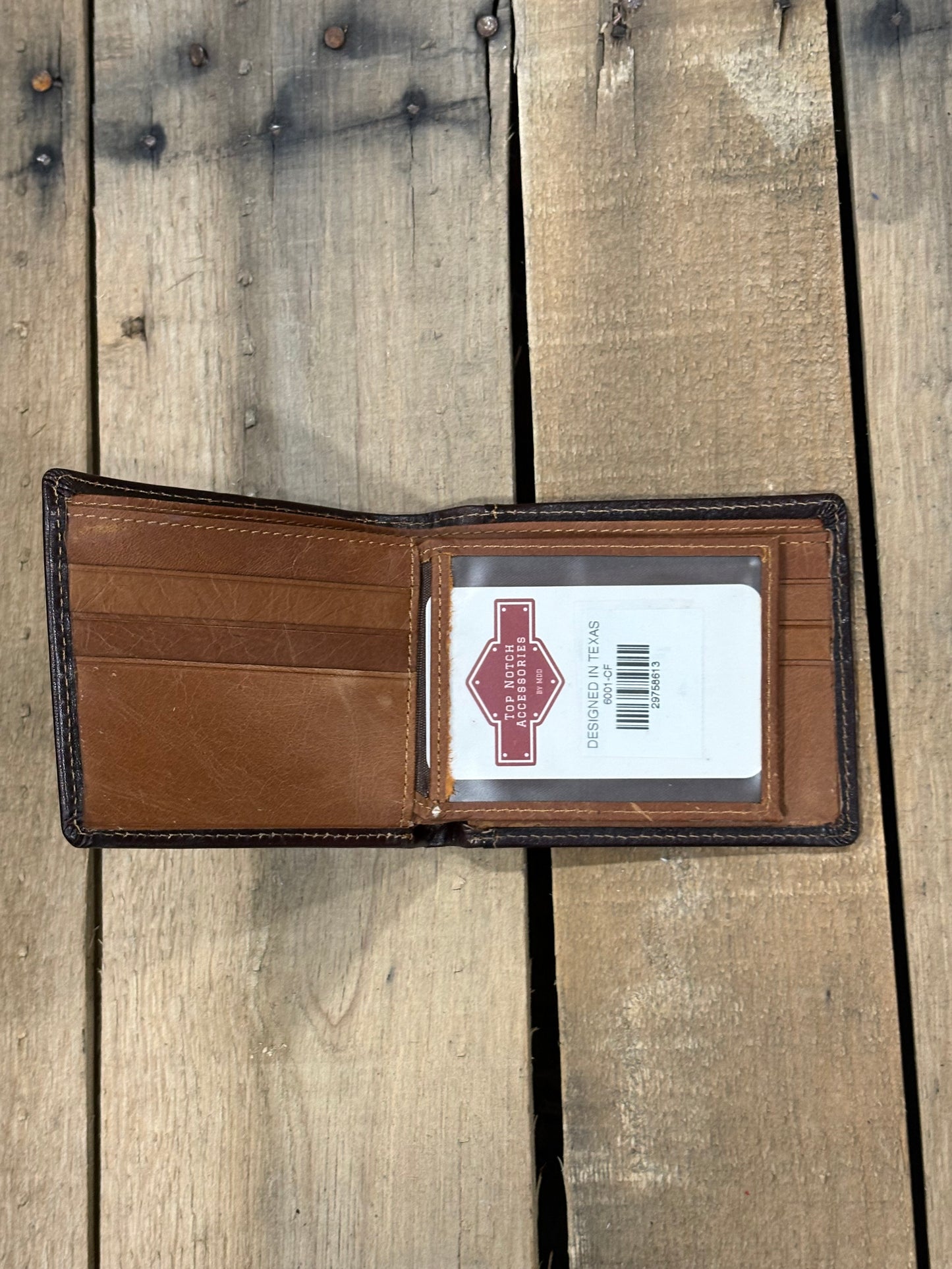 Brown leather wallet with a Top Notch Accessories card inside ID window slot on a wooden surface