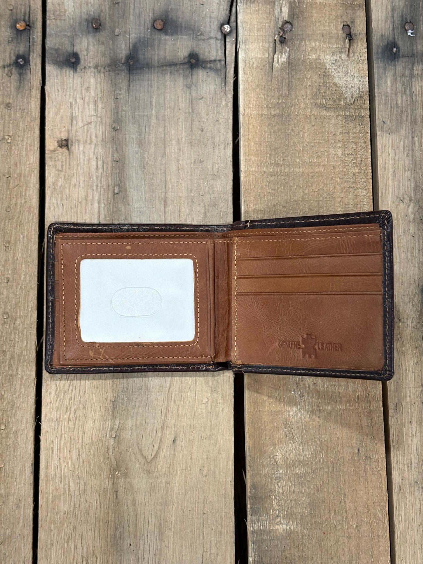 Brown leather wallet with a ID window slot on a wooden surface