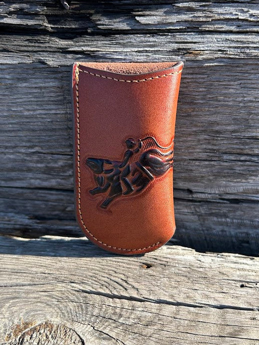 Brown leather knife sheath with a embossed Bull Rider design. Front View