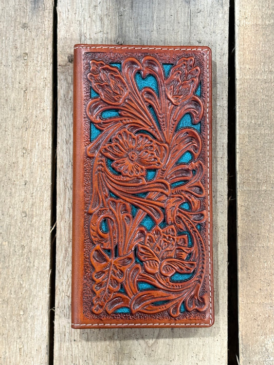 Light Brown leather wallet with intricate floral patterns on a striped fabric surface with a wooden wheel in the background.