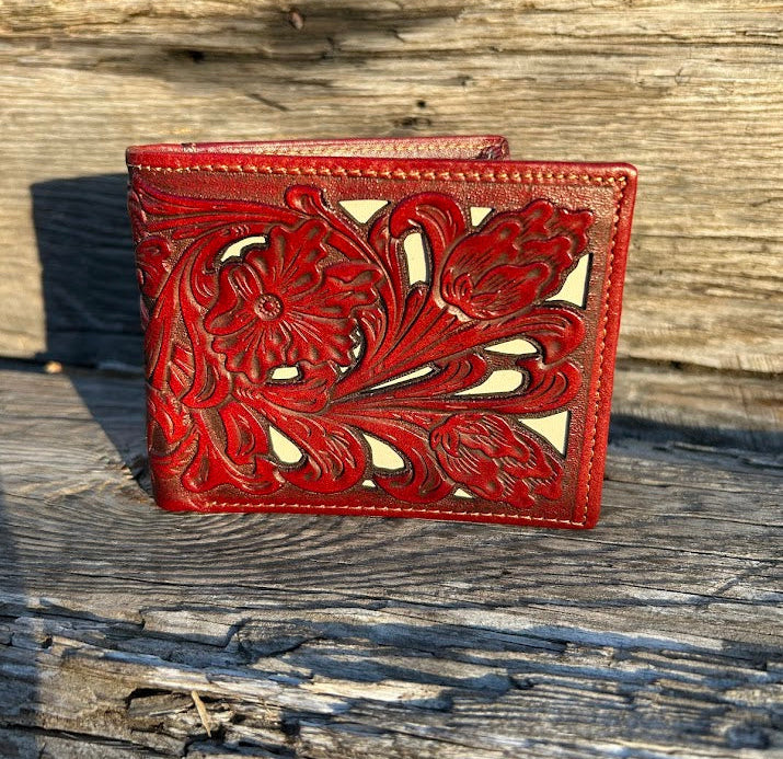 Brown leather wallet with floral tooling on a wooden surface