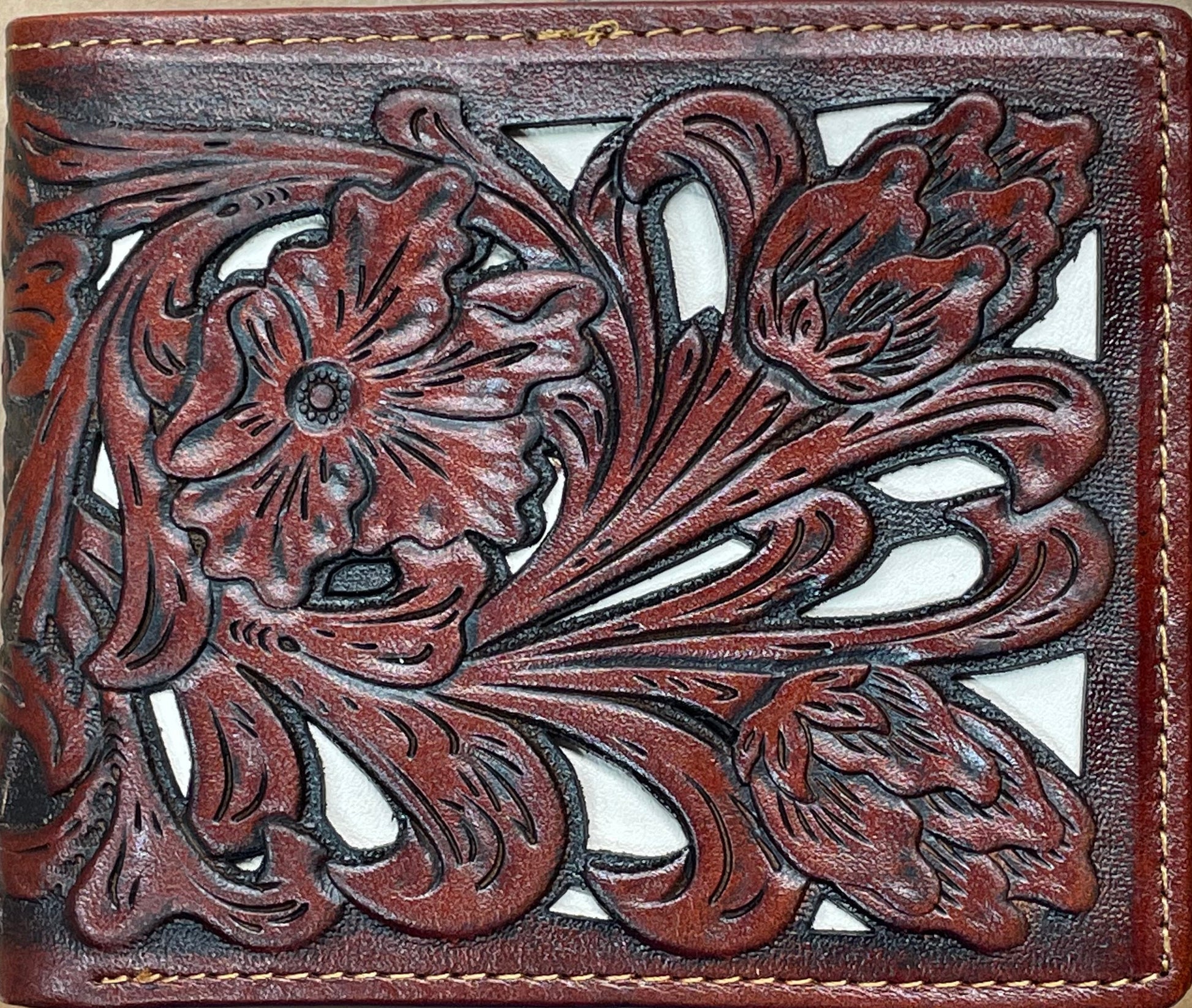 Close up of a Brown leather bifold wallet with Beige Inlay features a intricate tooled leather pattern. Front View