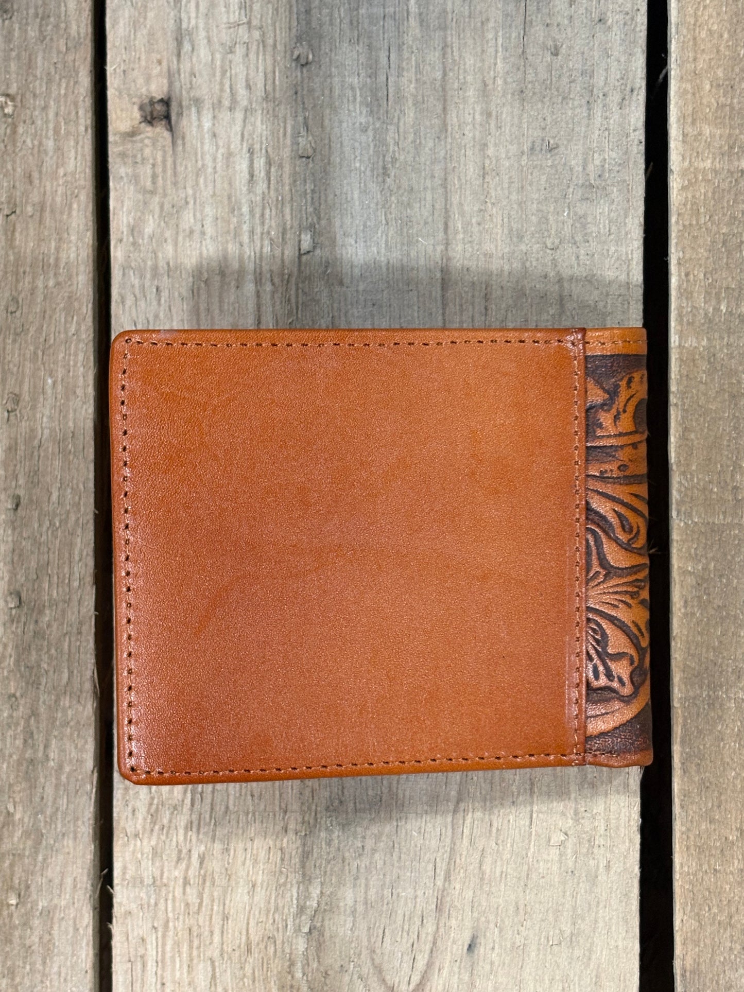 Light Brown leather wallet with decorative top section on a wooden surface