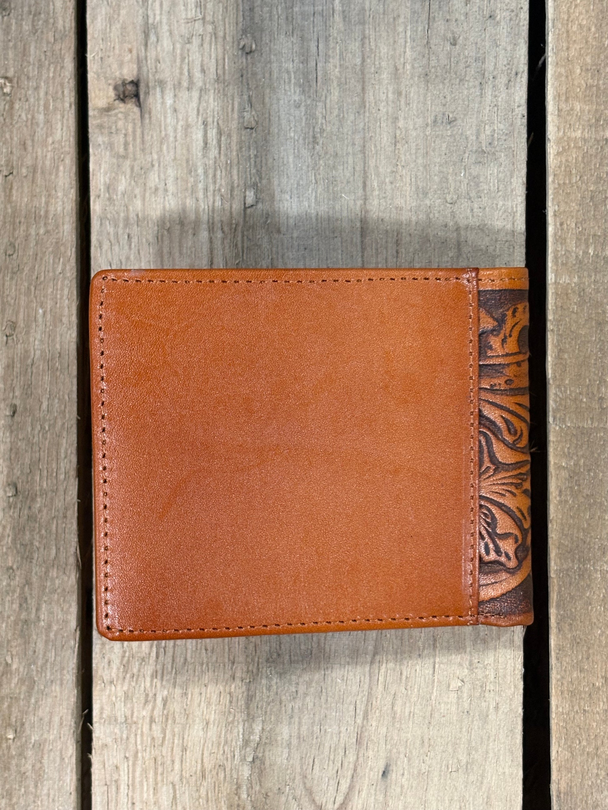 Light Brown leather wallet with decorative top section on a wooden surface