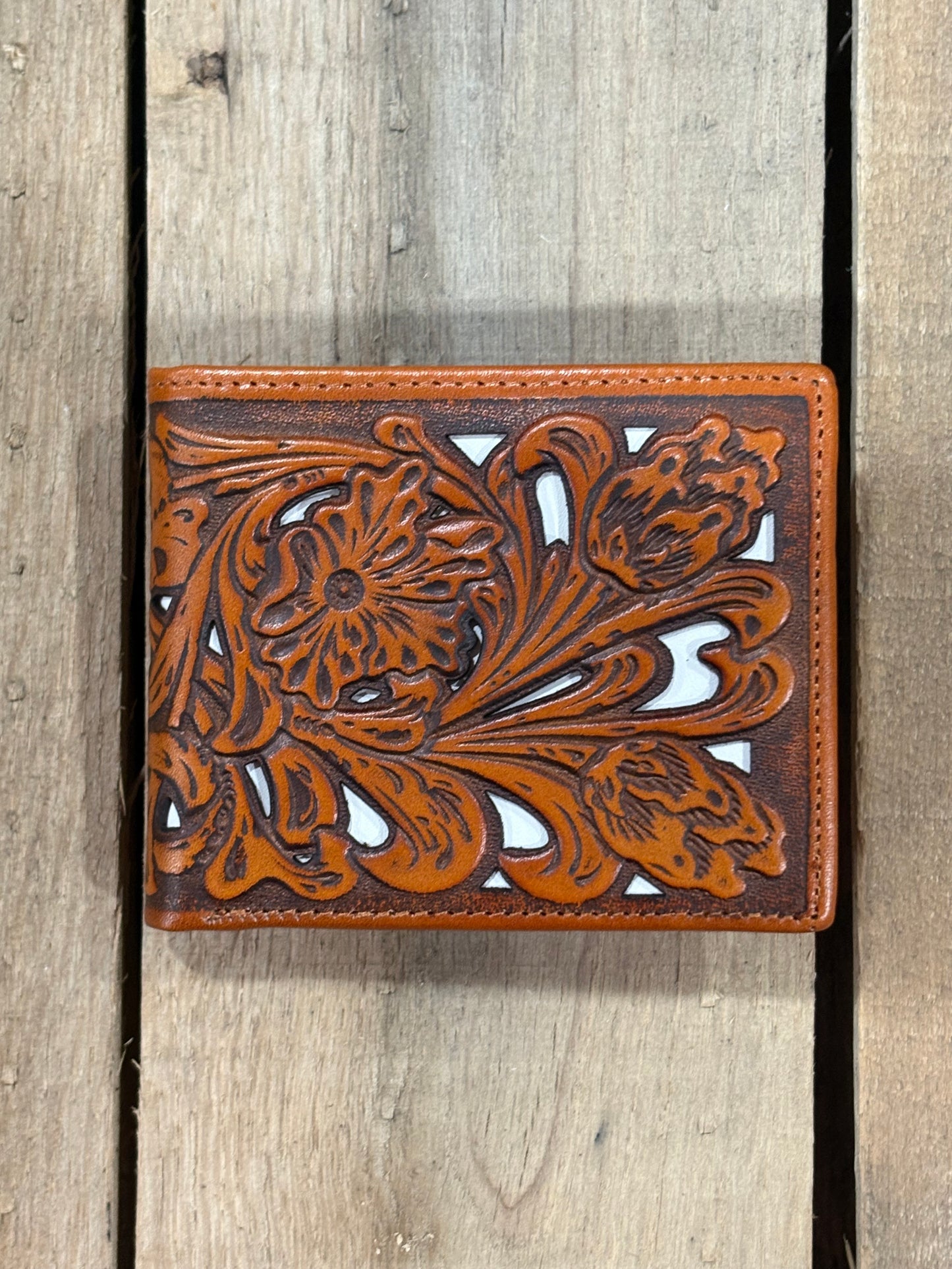 Light Brown leather wallet with floral patterns on a wooden surface