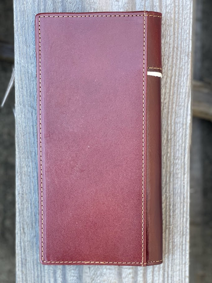 Brown leather-bound book or notebook on a textured surface