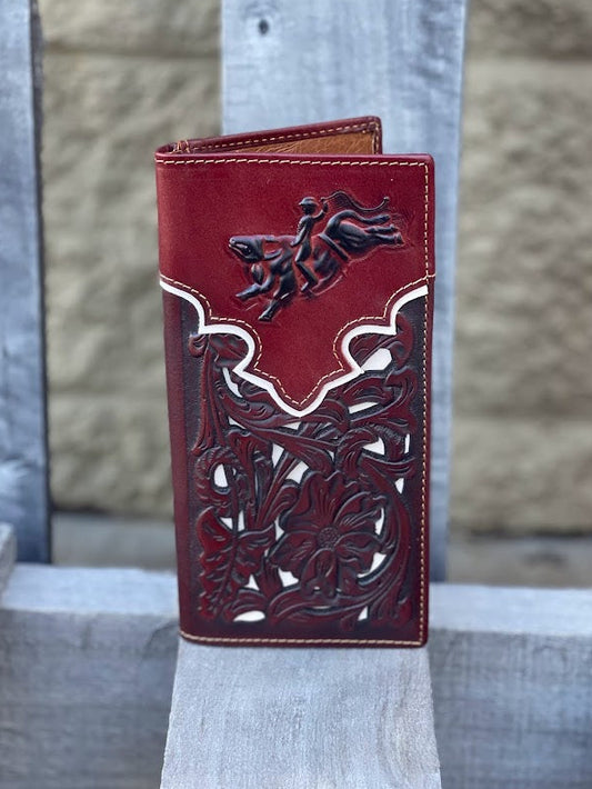 Brown leather wallet with embossed bull rider intricate designs on a wood surface
