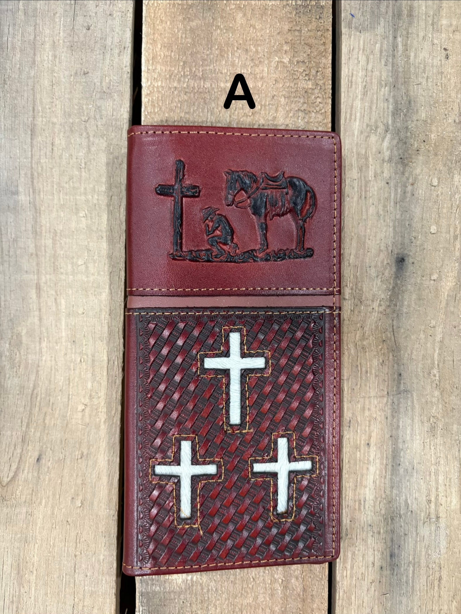 Brown leather cover with embossed designs of crosses and a horse, featuring metal cross symbols.