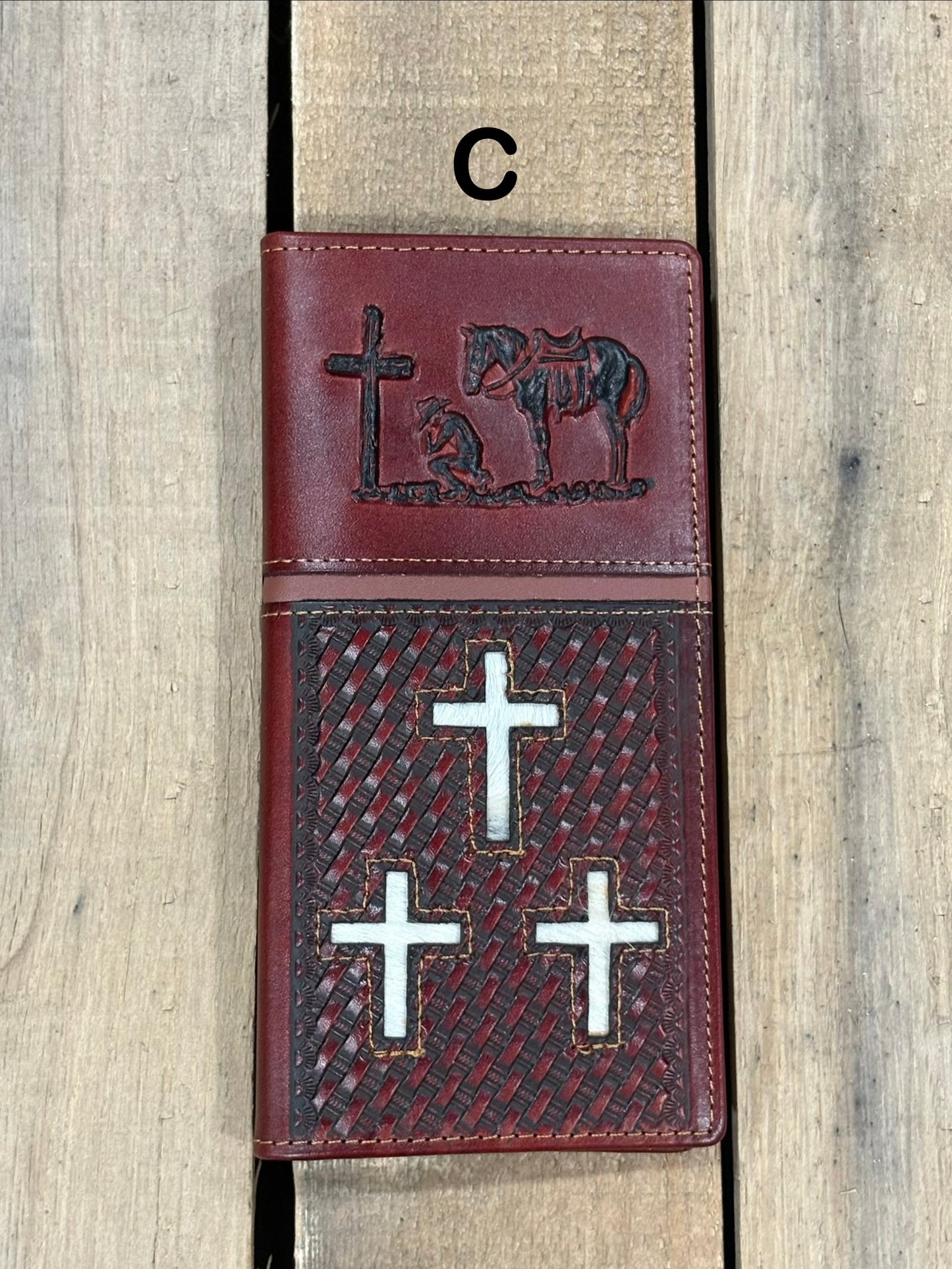 Brown leather cover with embossed designs of crosses and a horse, featuring metal cross symbols.