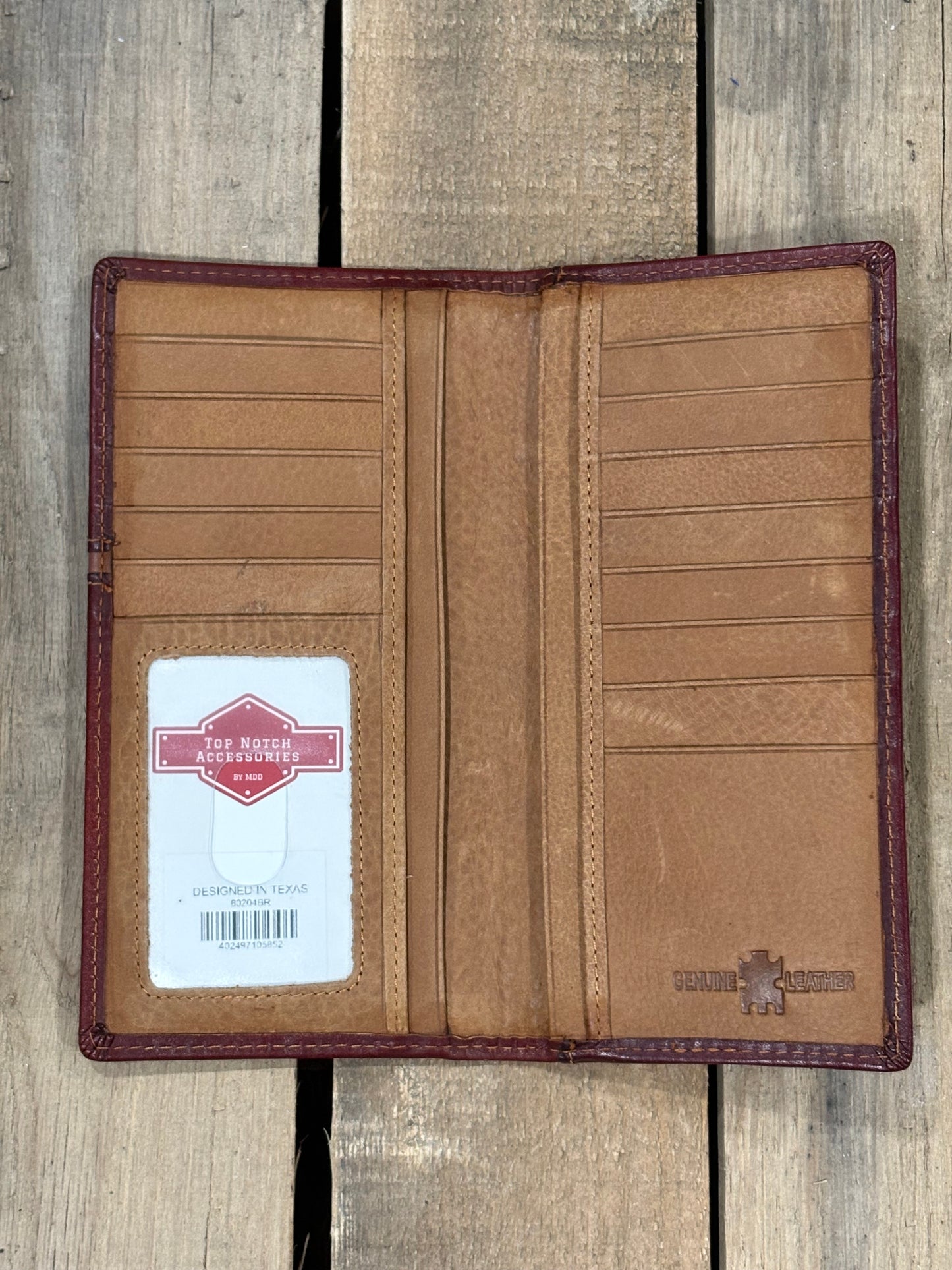 Brown leather wallet with a visible brand label on a wooden surface