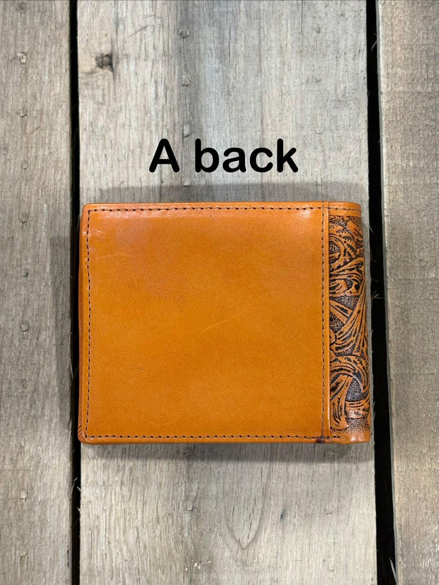 Light Brown leather wallet with intricate design on a wooden surface