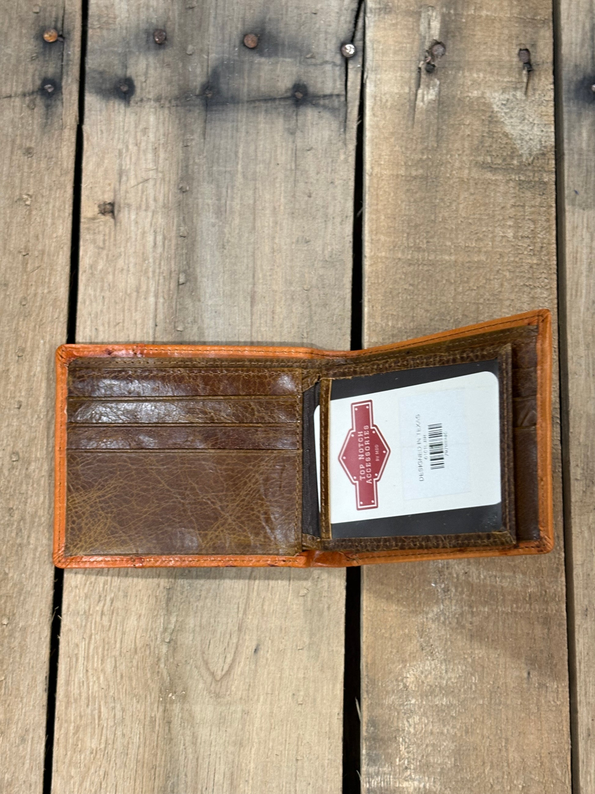 Brown leather wallet with a Top Notch Accessories card inside the ID window slot and 3 card slots on a wooden surface