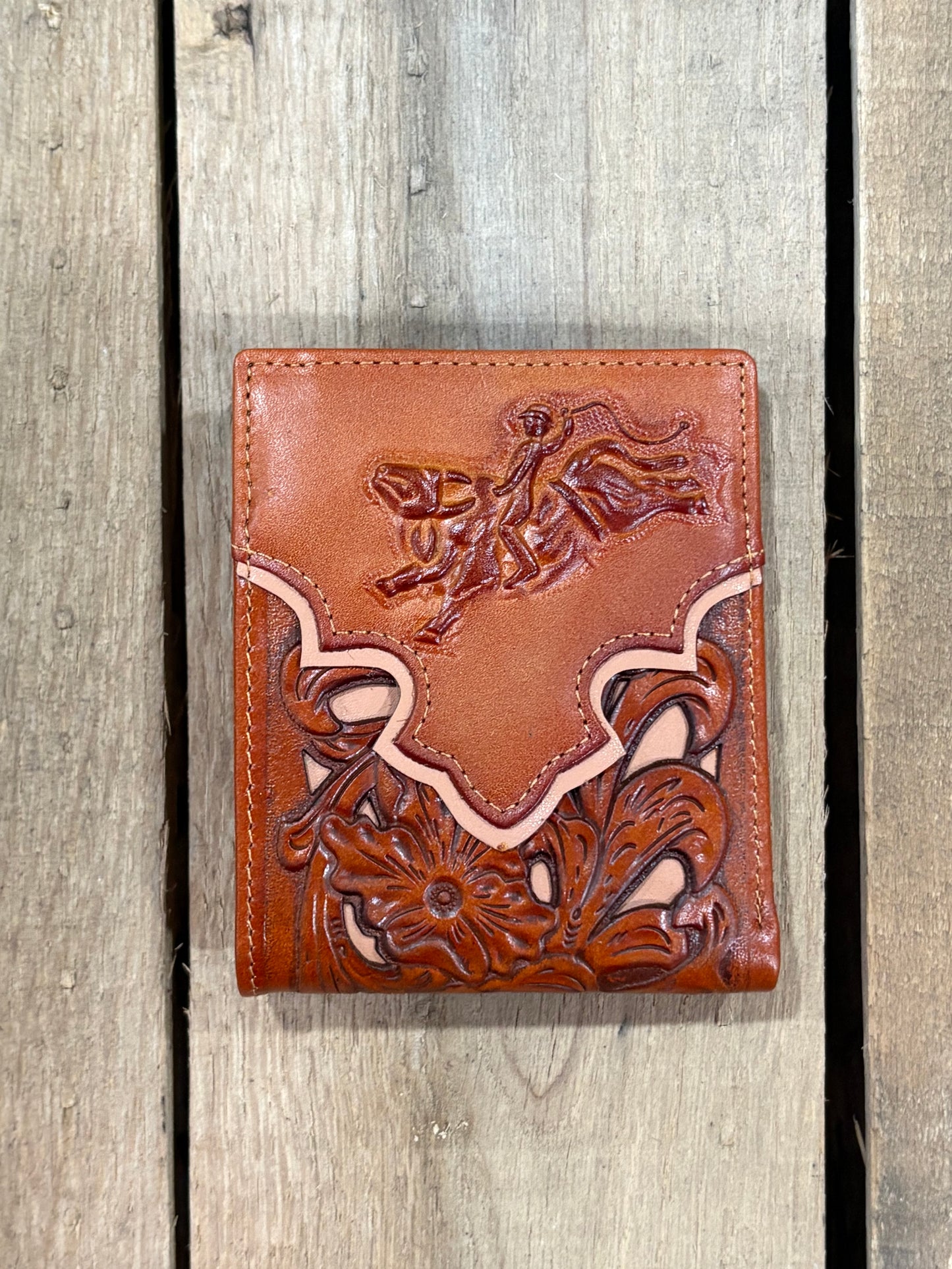 Light Brown leather wallet with floral embossing on a wooden surface
