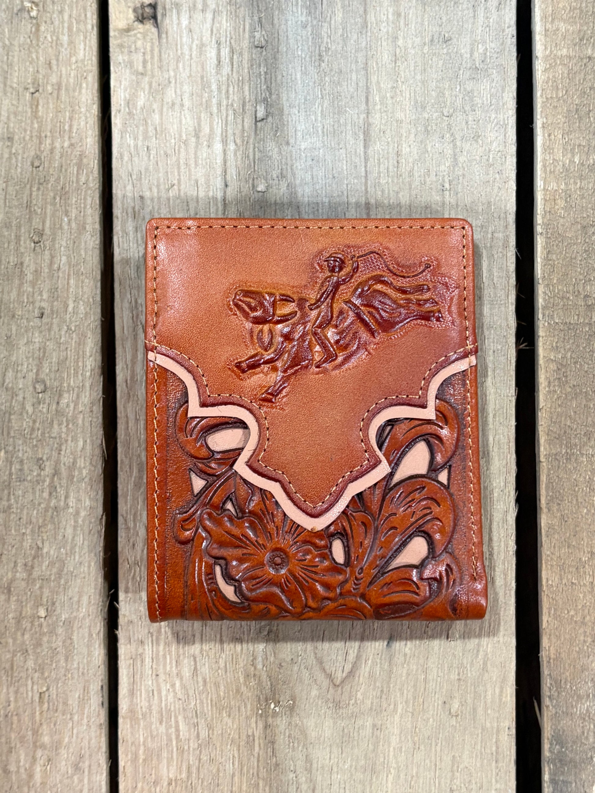 Light Brown leather wallet with floral embossing on a wooden surface