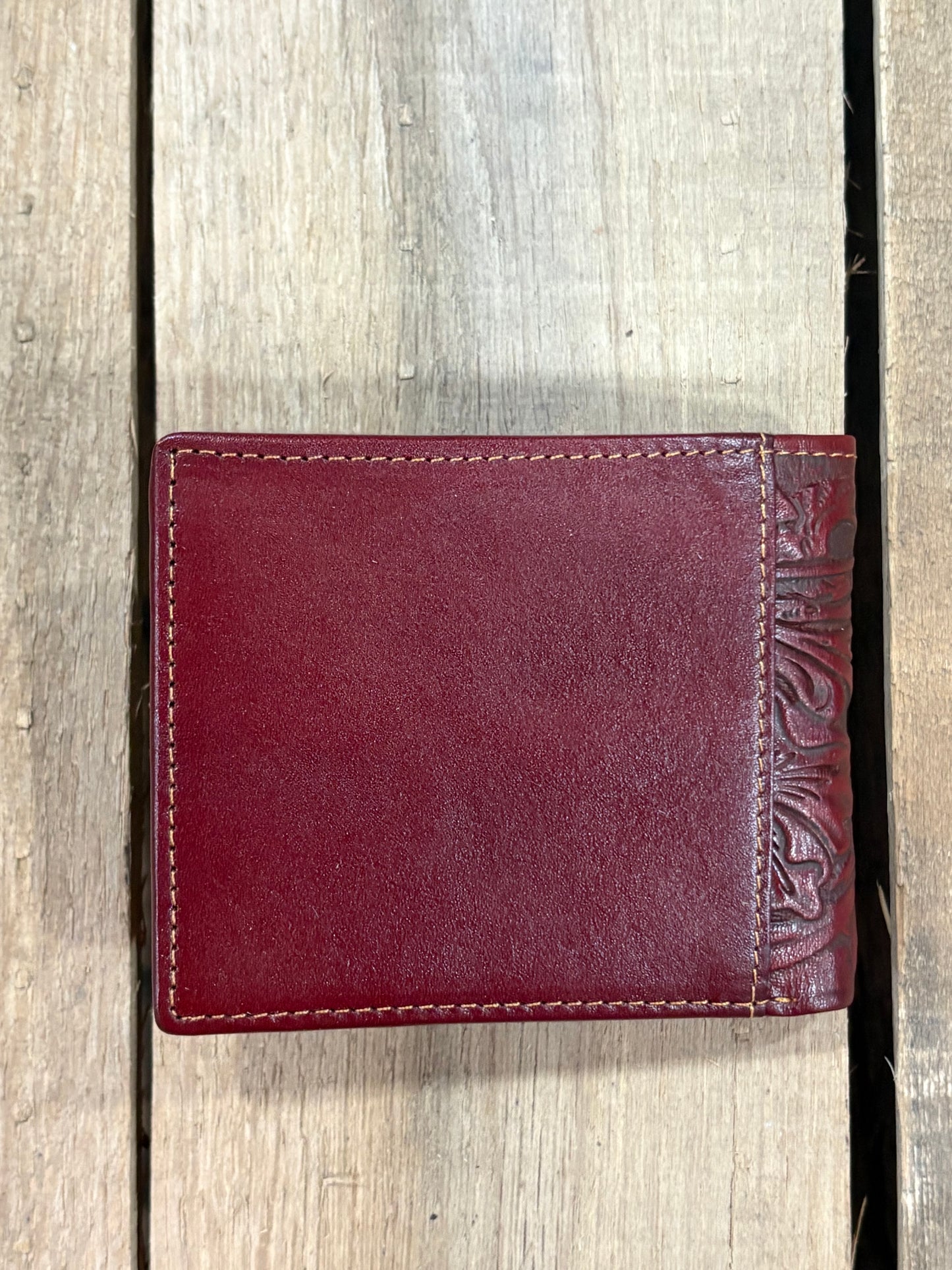 Brown smooth leather wallet on a wooden surface
