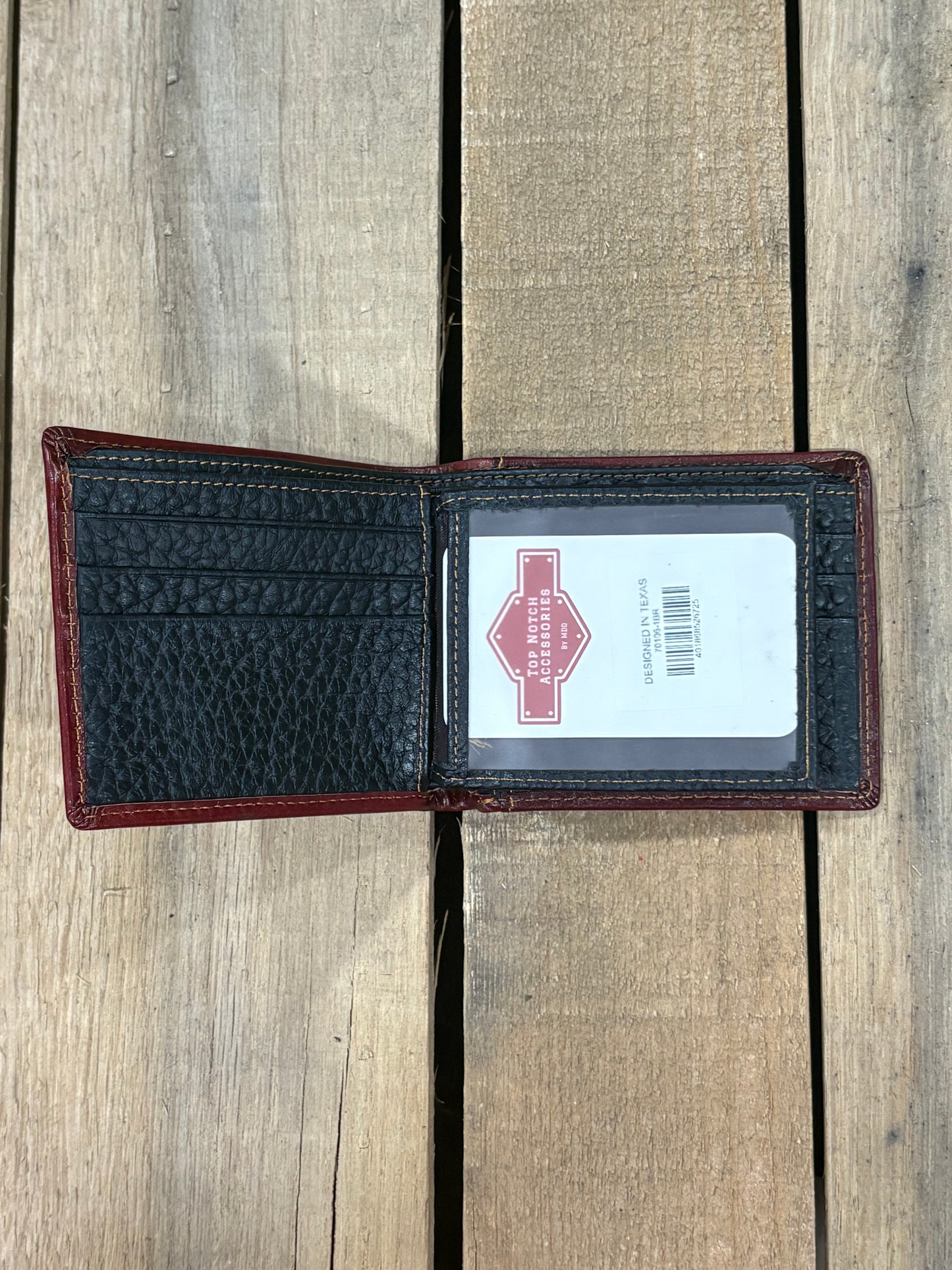 Black pebbled leather inside wallet with three card slots and one ID window slot on a wooden surface