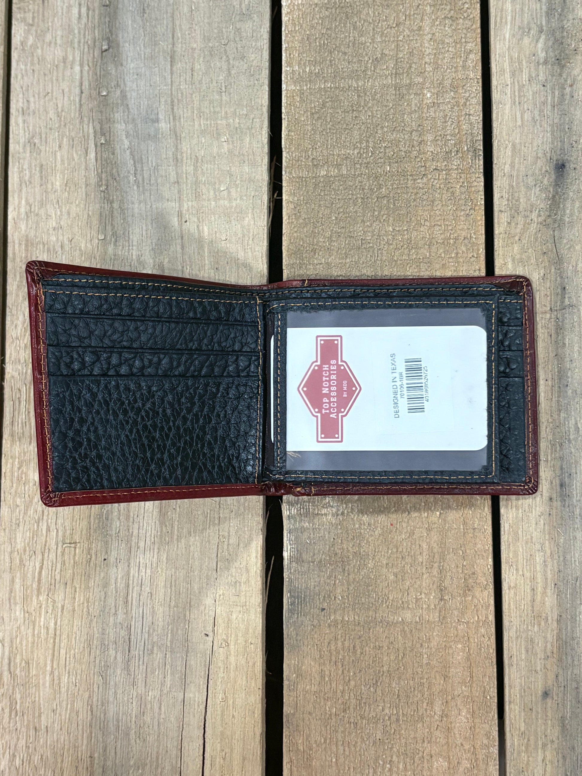 Black pebbled leather inside wallet with three card slots and one ID window slot on a wooden surface
