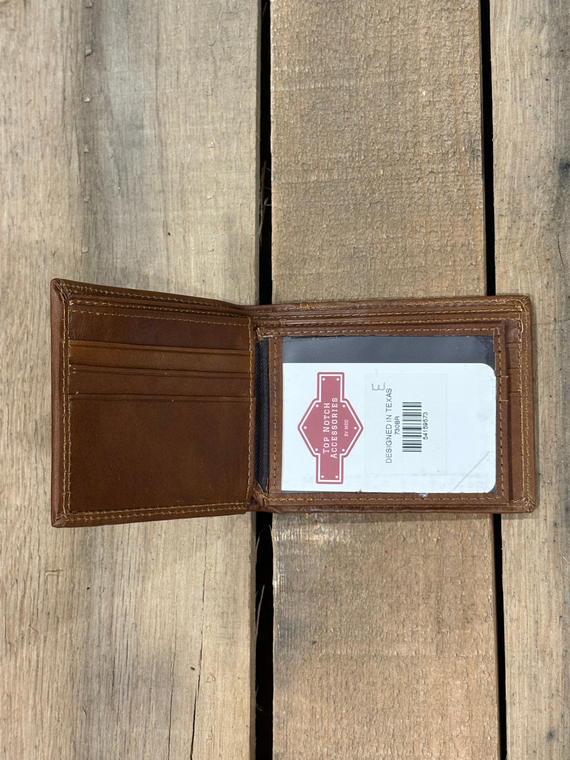 Brown leather wallet with a brand label on a wooden surface