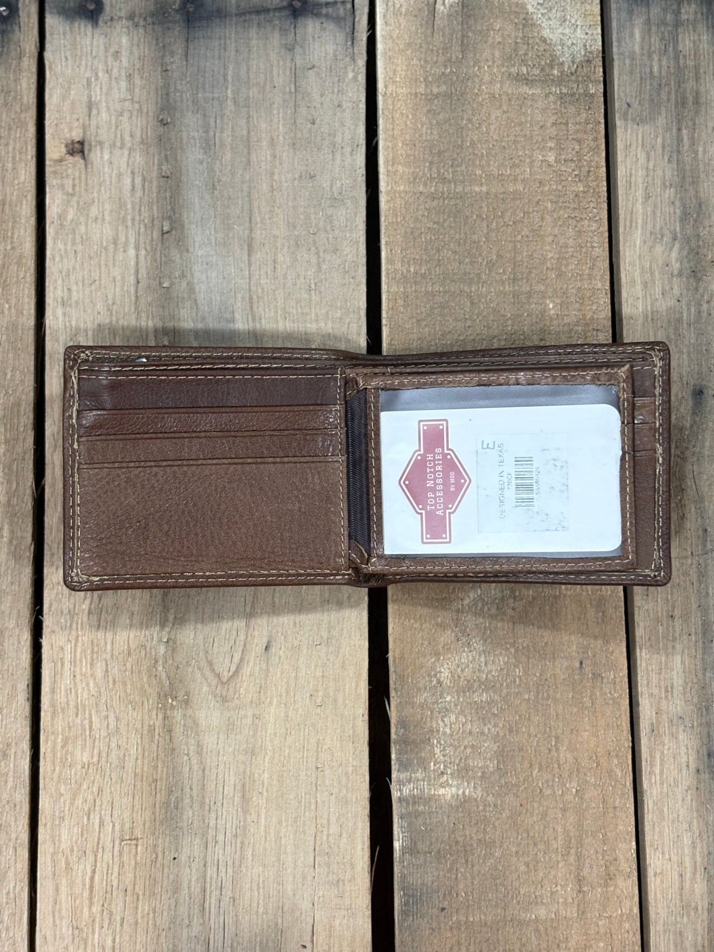 Coffee Brown smooth leather wallet with a visible brand label on a wooden surface