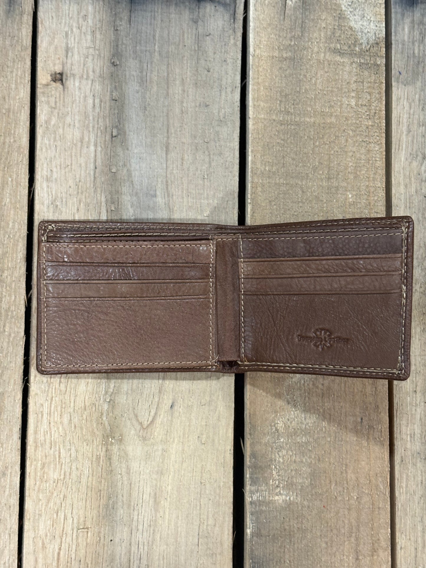 Coffee Brown smooth leather wallet with a visible brand label on a wooden surface