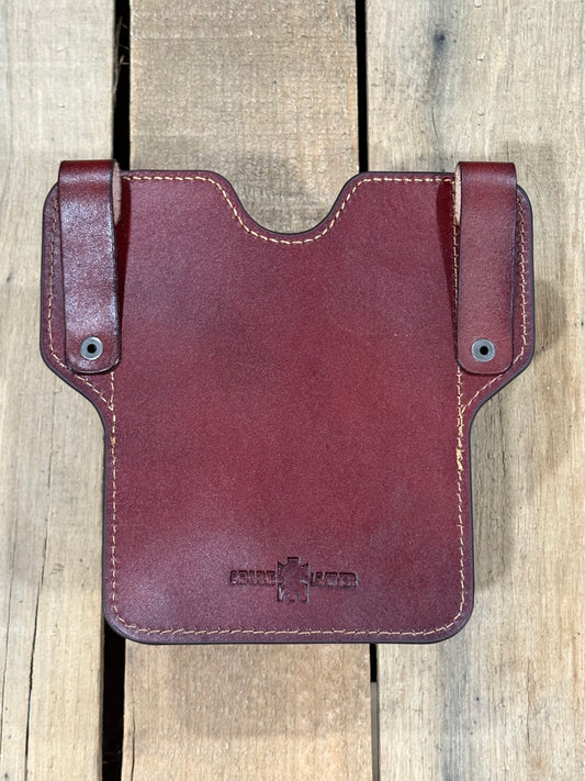 Back view brown phonecase with belt loop straps on a wooden surface.
