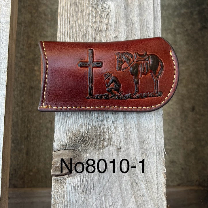 This Brown leather knife sheath from Top Notch Accessories features a embossed Praying Cowboy design and a leather belt attachment. Front View