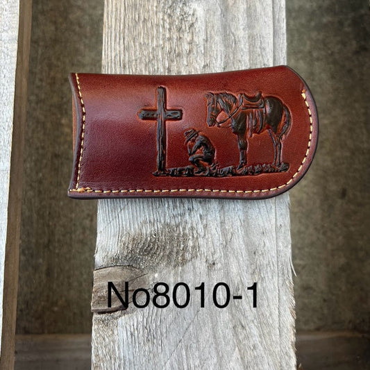This Brown leather knife sheath from Top Notch Accessories features a embossed Praying Cowboy design and a leather belt attachment. Front View
