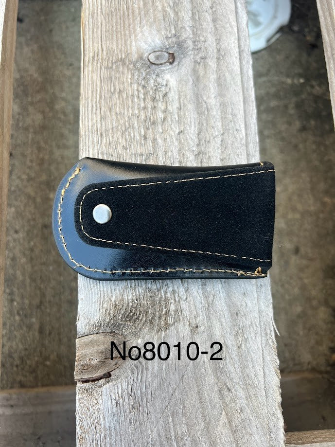 Black leather sheath on a wooden surface with 'No8010-2' label.