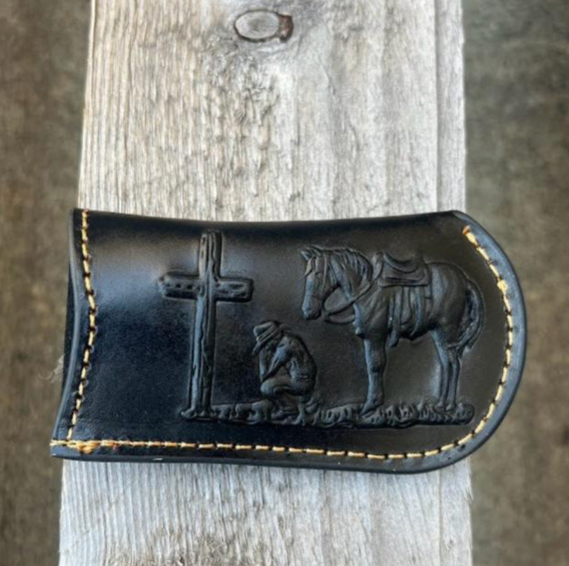 This Black leather knife sheath from Top Notch Accessories features an embossed Praying Cowboy design. Front View