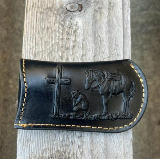 This Black leather knife sheath from Top Notch Accessories features an embossed Praying Cowboy design. Front View