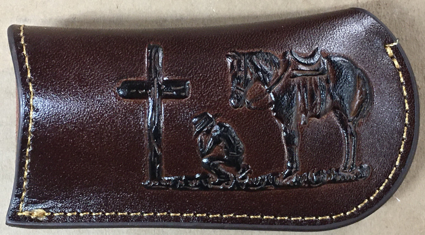 Coffee Brown leather case with black metal cross, kneeling figure, and horse embossing on a beige background
