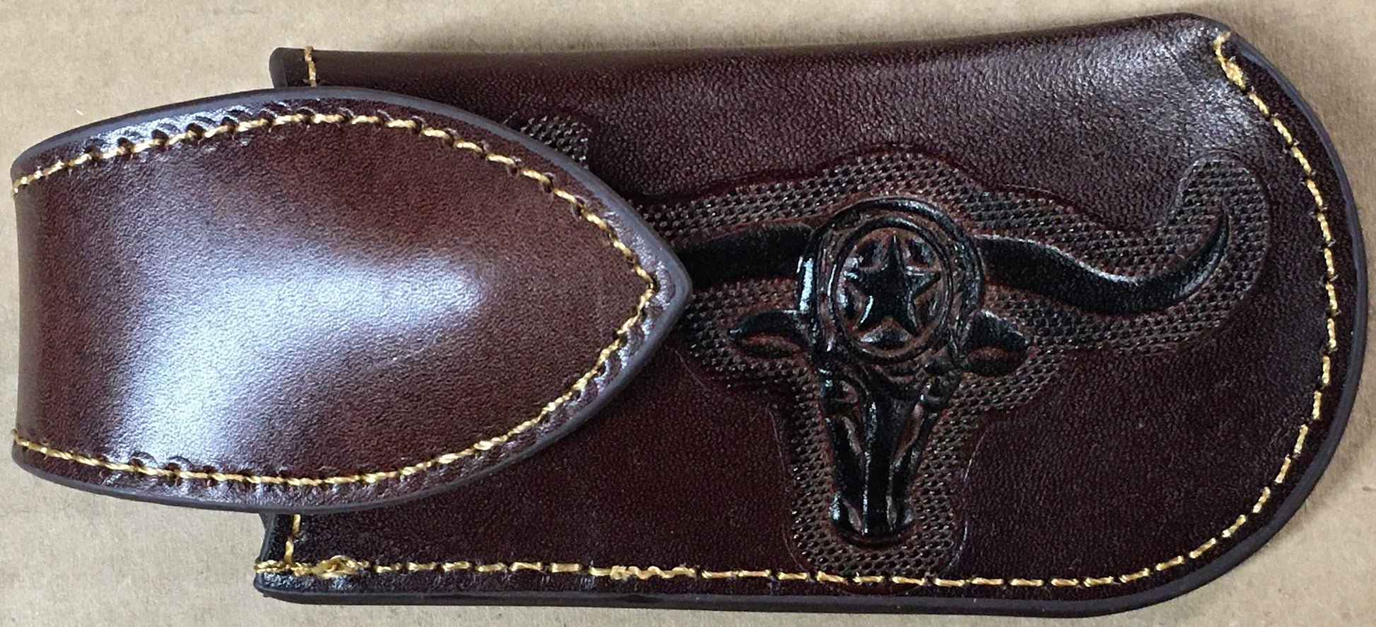 A Coffee Brown leather knife sheath with a decorative longhorn and star design.