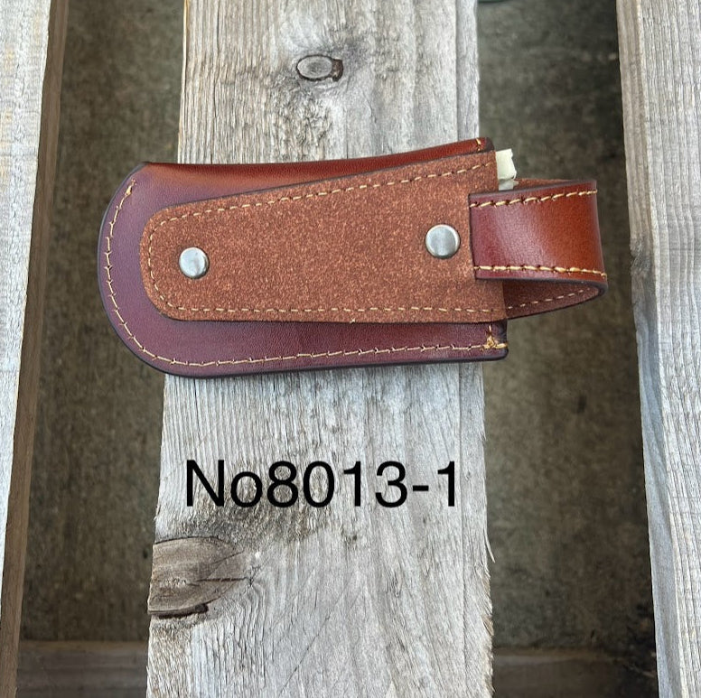 A brown leather knife sheath with a embossed Praying Cowboy. Rear view showing belt loop. 