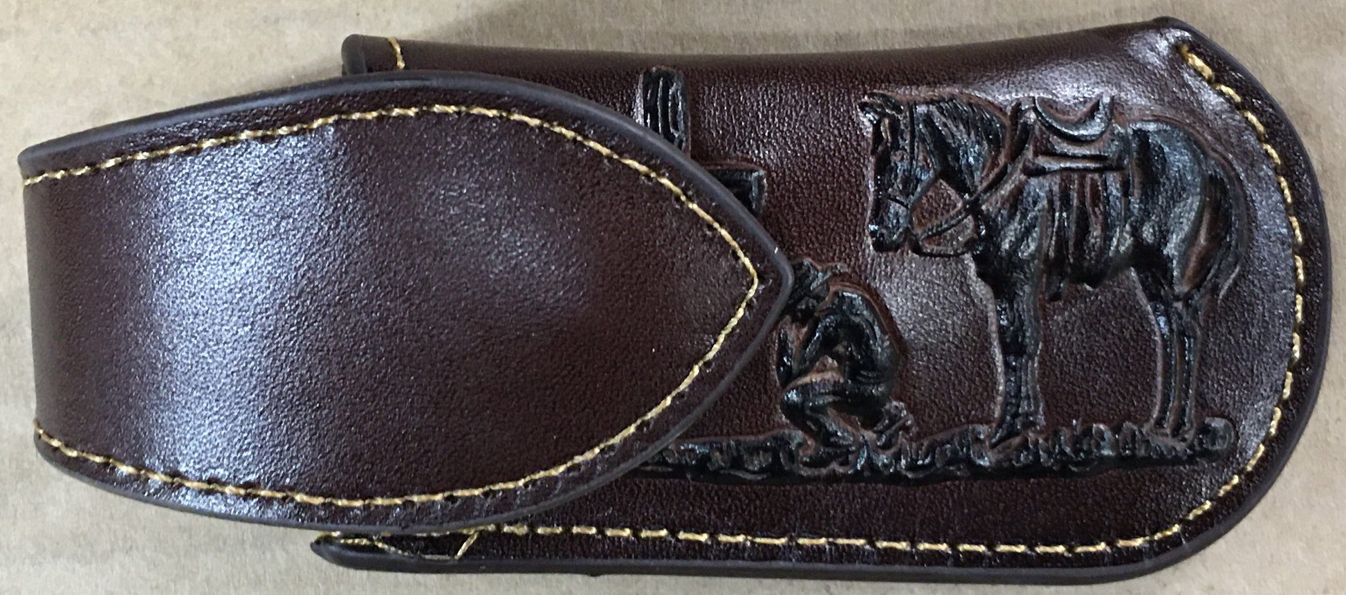 Coffee Brown leather sheath with horse design on a beige background